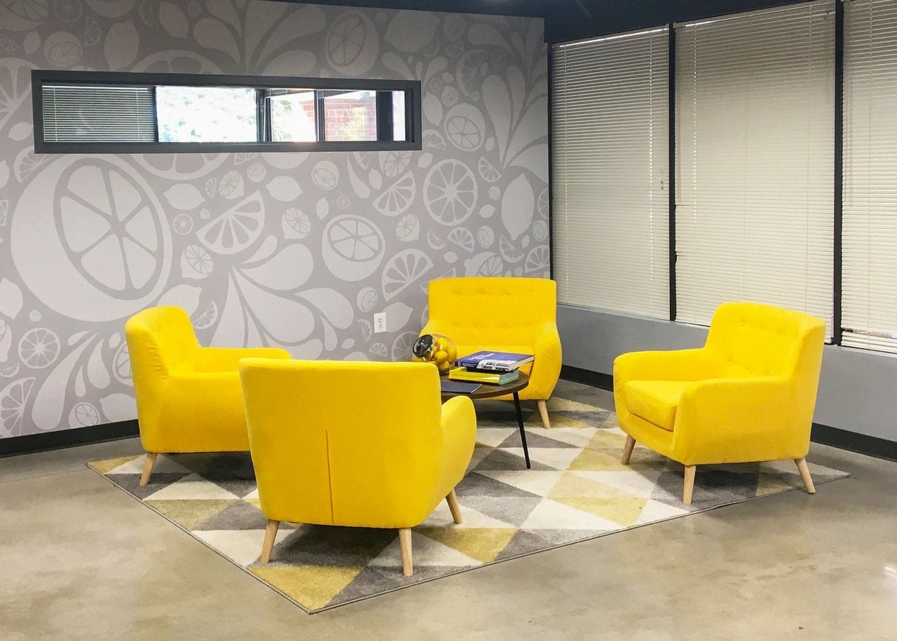 office lounge with four yellow chairs facing each other