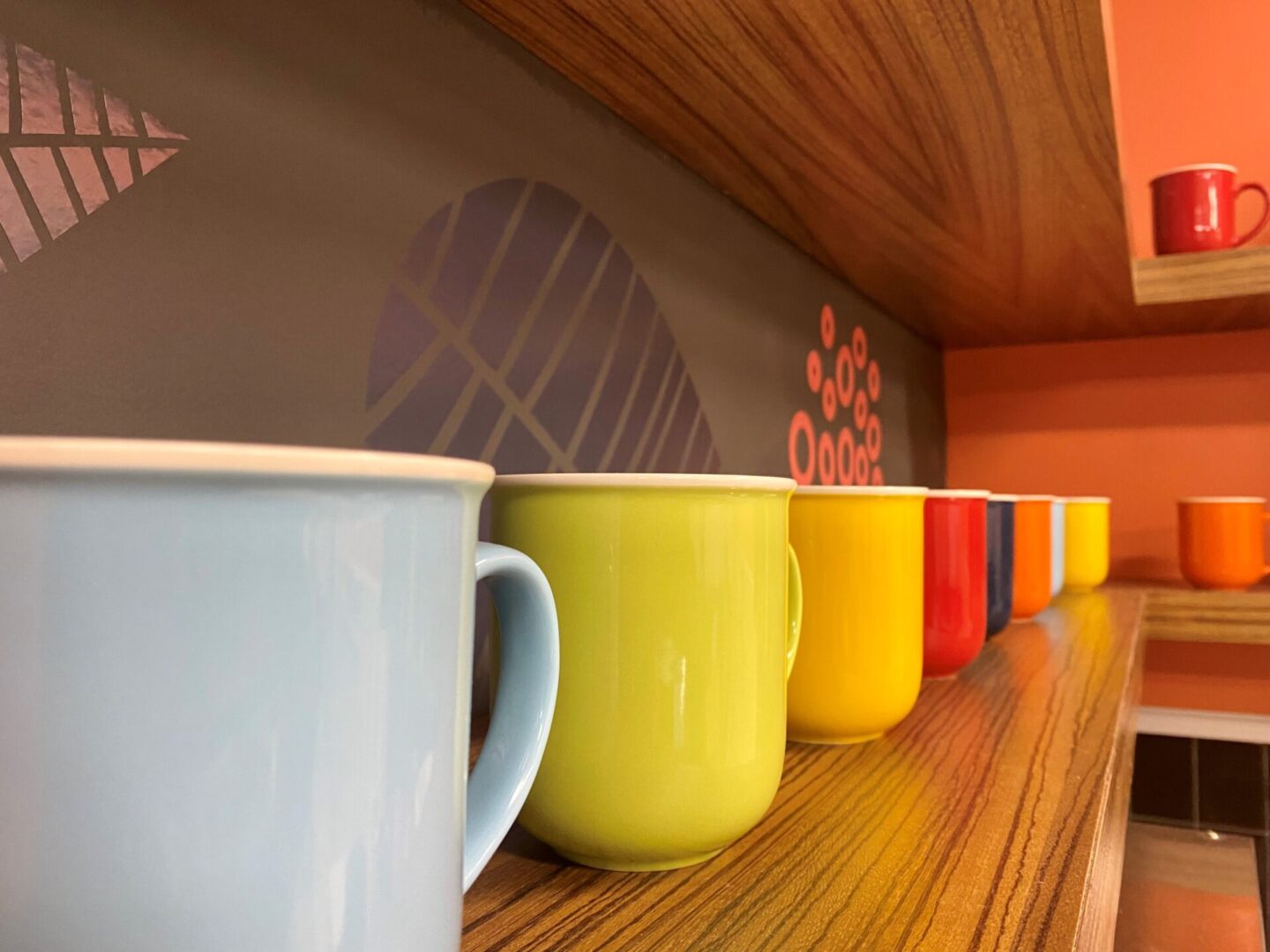Multi colored coffee mugs on display rack